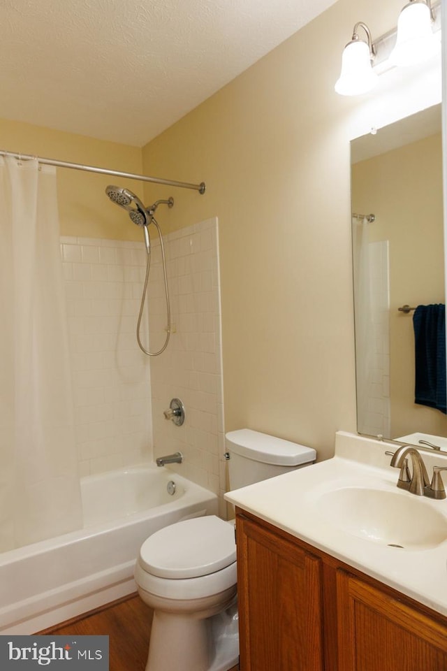 full bathroom featuring hardwood / wood-style floors, vanity, toilet, shower / bath combo, and a textured ceiling