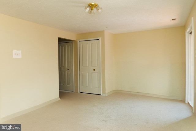 unfurnished bedroom with carpet flooring, a textured ceiling, and a closet