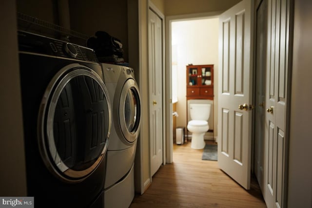 washroom featuring separate washer and dryer and light hardwood / wood-style flooring