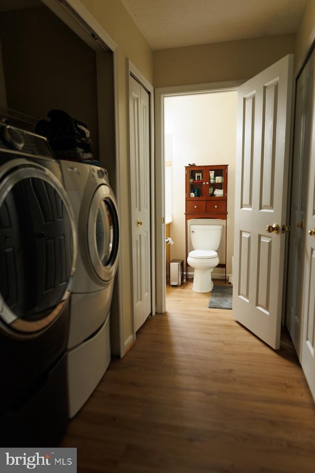 laundry area featuring wood-type flooring and washer and dryer