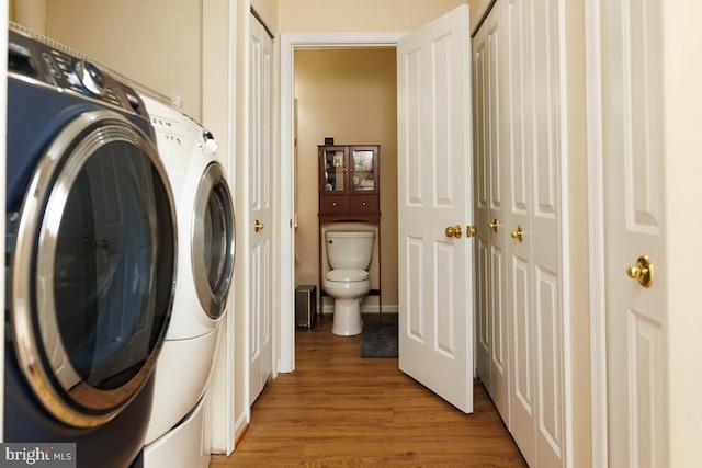 clothes washing area featuring washer / dryer and light hardwood / wood-style floors