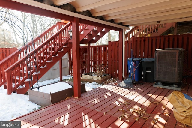 snow covered deck featuring central air condition unit