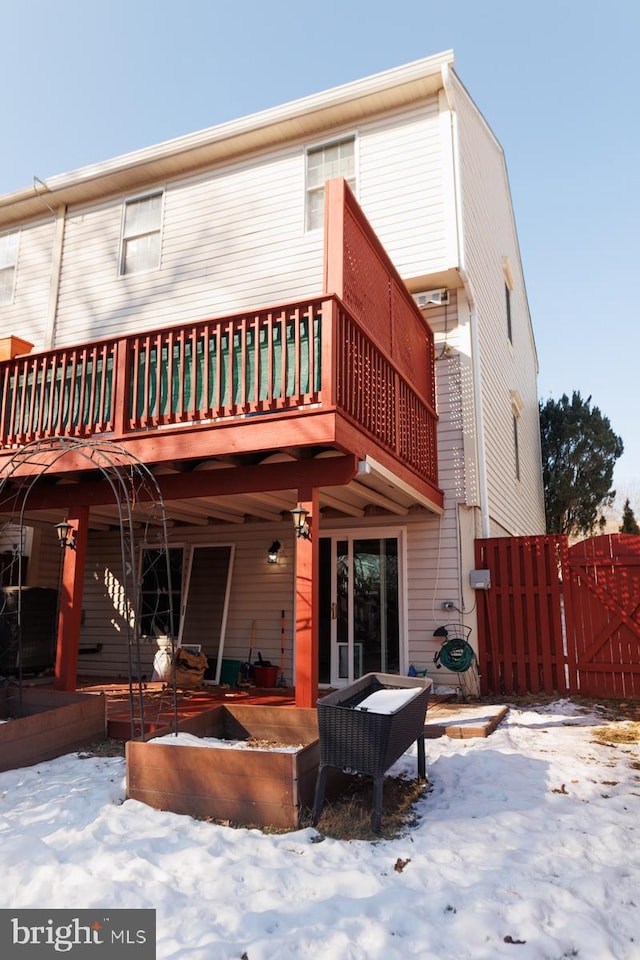 snow covered property with a wooden deck