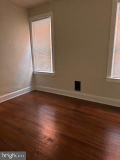 spare room with dark wood-type flooring