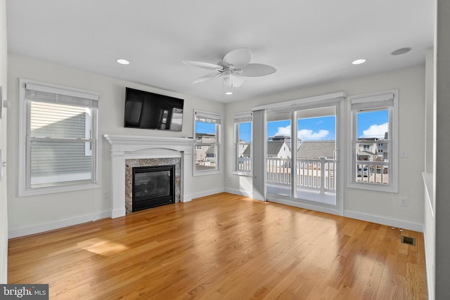 unfurnished living room featuring light wood-style flooring, a fireplace, visible vents, and baseboards