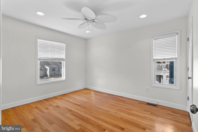 unfurnished room with plenty of natural light, baseboards, and light wood-style flooring