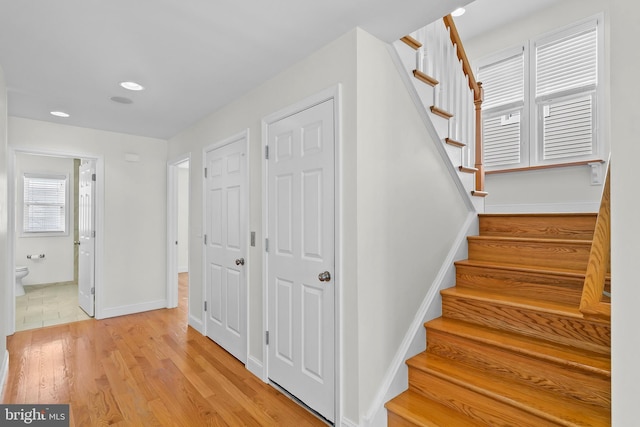 staircase with recessed lighting, wood finished floors, and baseboards