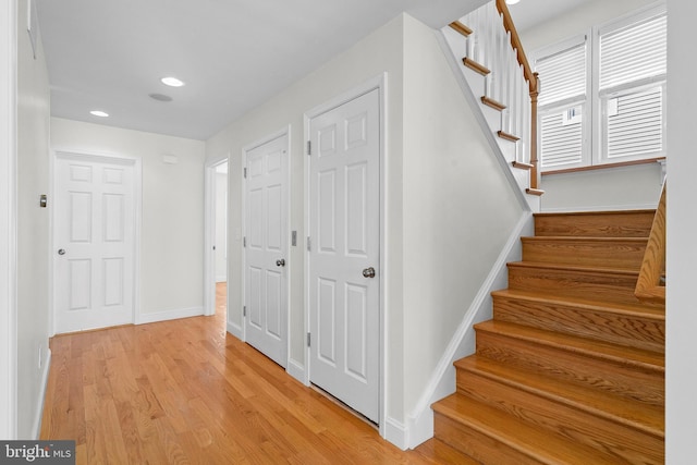 staircase with recessed lighting, wood finished floors, and baseboards