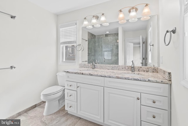 full bathroom with toilet, a sink, baseboards, a shower stall, and double vanity