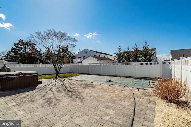 view of patio / terrace featuring a hot tub, a fenced in pool, and a fenced backyard