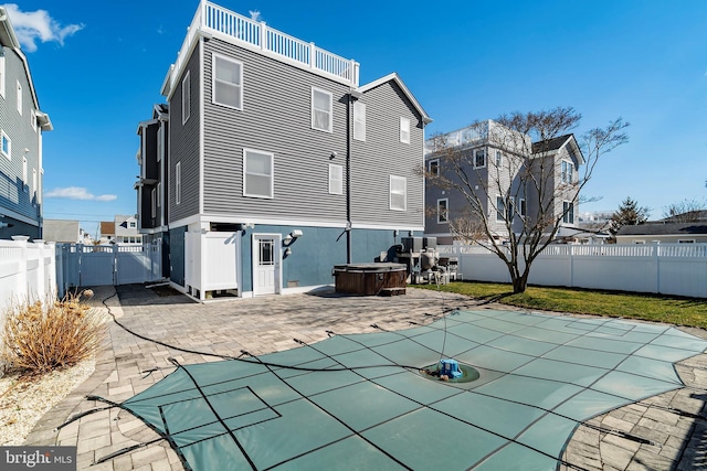 back of property featuring a fenced in pool, a gate, a fenced backyard, and a patio