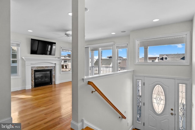 foyer with baseboards, ceiling fan, wood finished floors, a fireplace, and recessed lighting