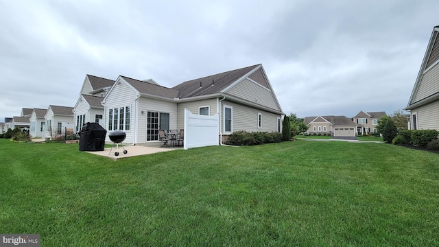 back of property with a yard and a patio