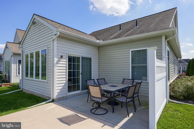 rear view of property featuring a patio and a lawn