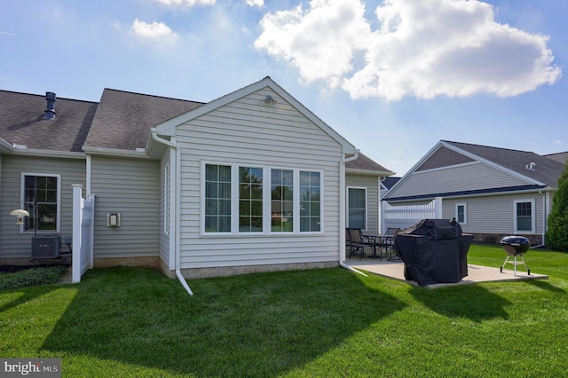 rear view of property with a yard and a patio area