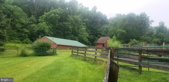 view of yard with an outbuilding and a rural view