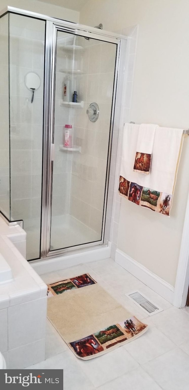 bathroom featuring a shower with shower door and tile patterned flooring