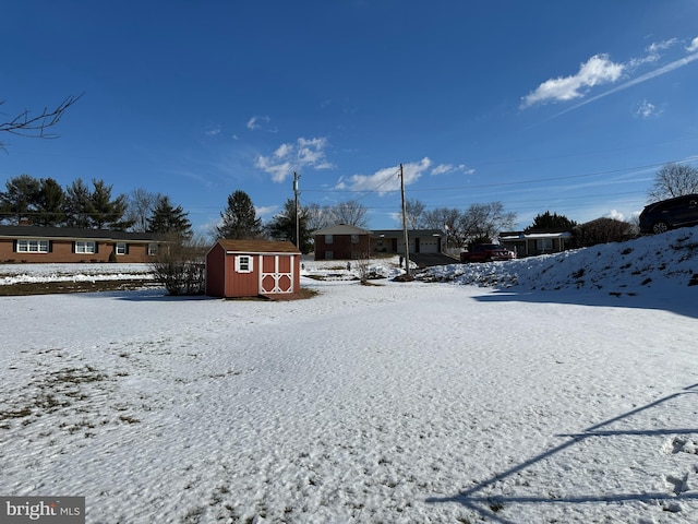 yard layered in snow with a shed