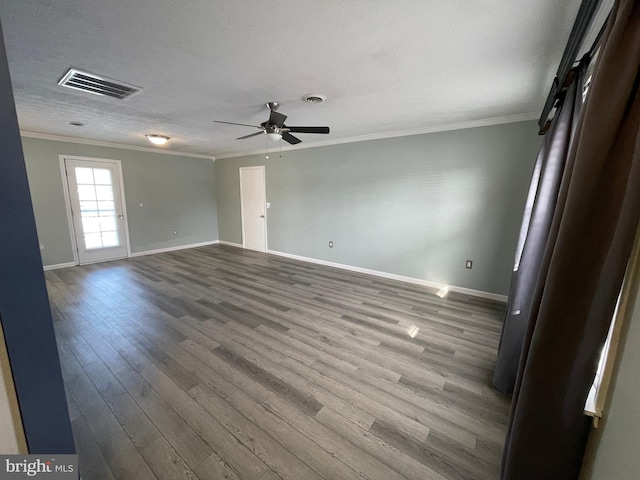 spare room featuring hardwood / wood-style flooring, ornamental molding, a textured ceiling, and ceiling fan