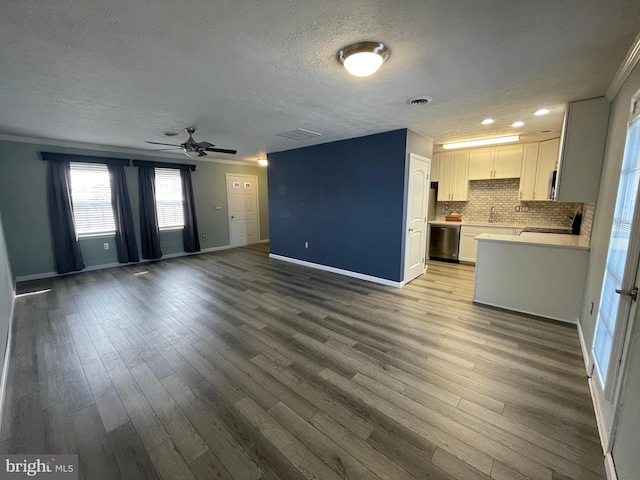 kitchen with white cabinetry, dishwasher, decorative backsplash, and hardwood / wood-style flooring