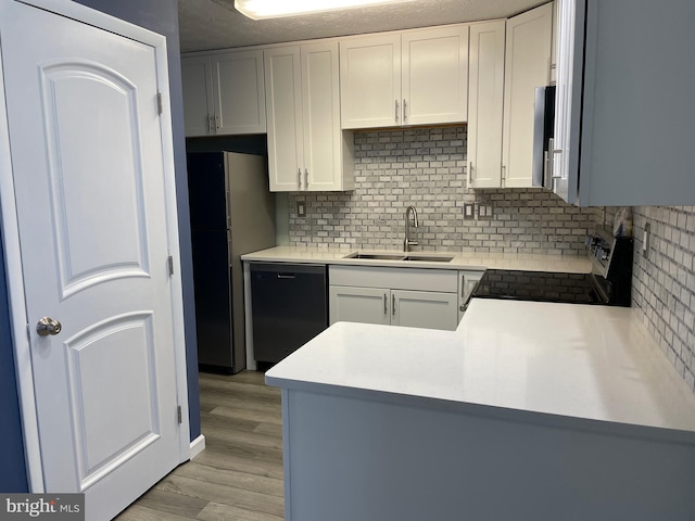 kitchen with stainless steel appliances, sink, decorative backsplash, and white cabinets