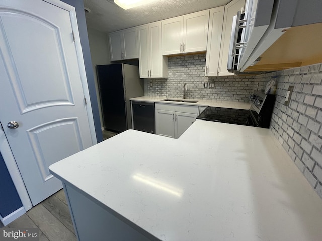 kitchen with stainless steel stove, tasteful backsplash, dishwasher, sink, and white cabinets