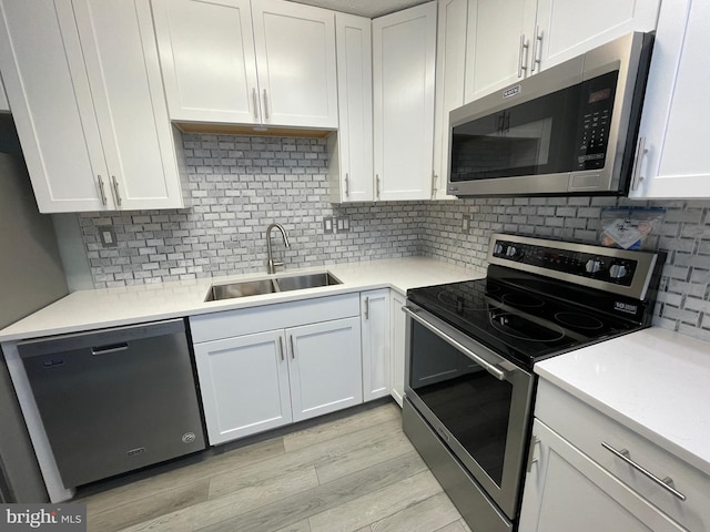 kitchen featuring appliances with stainless steel finishes, sink, and white cabinets