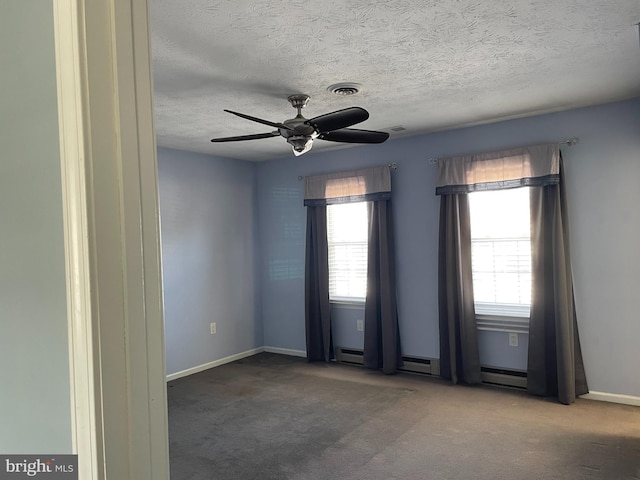 carpeted empty room featuring plenty of natural light, a baseboard heating unit, a textured ceiling, and ceiling fan