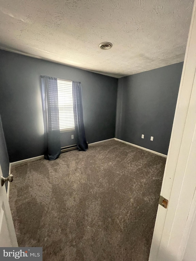 carpeted spare room with a textured ceiling