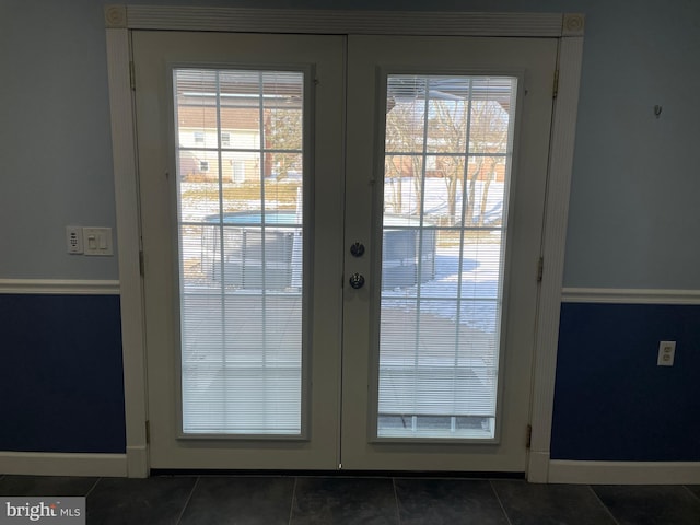 entryway with french doors and dark tile patterned flooring