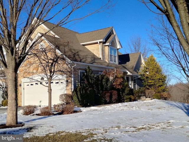 snow covered property with a garage