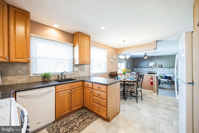 kitchen with a wealth of natural light, a sink, open floor plan, white appliances, and a peninsula