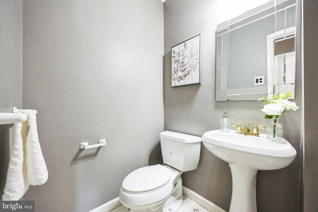 bathroom featuring toilet and baseboards