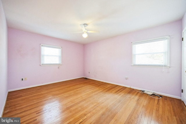 empty room with light wood-type flooring, baseboards, and a ceiling fan