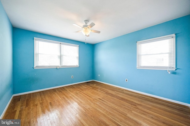 spare room featuring ceiling fan, baseboards, and hardwood / wood-style floors