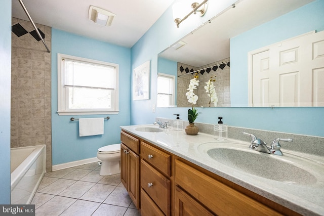 bathroom with tile patterned floors, toilet, double vanity, and a sink