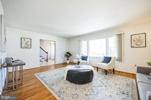 living area featuring stairway, baseboards, and wood finished floors