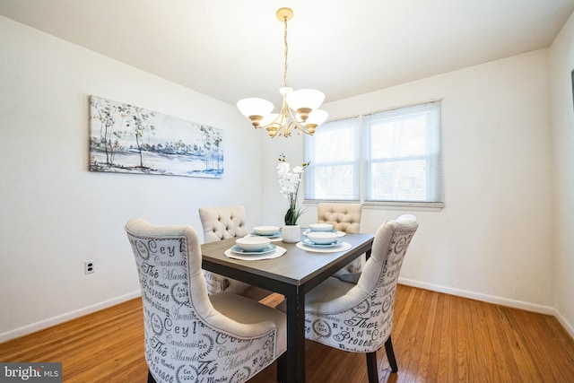 dining room with an inviting chandelier, baseboards, and light wood finished floors