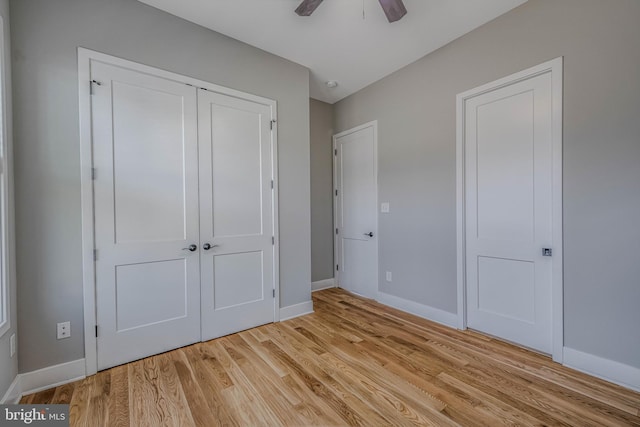 unfurnished bedroom featuring ceiling fan, light wood-type flooring, and a closet