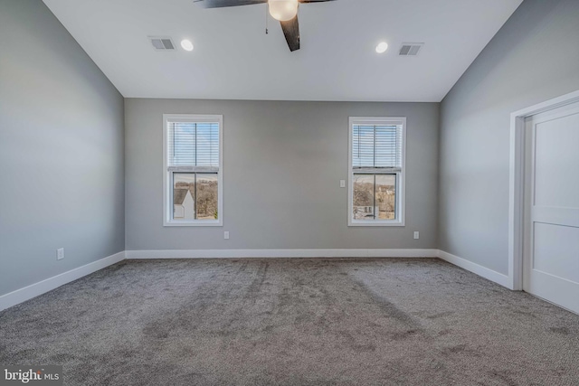 carpeted empty room featuring lofted ceiling, ceiling fan, and a healthy amount of sunlight