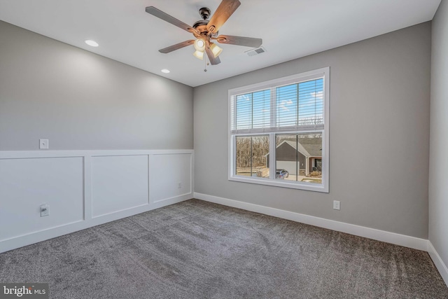 carpeted spare room featuring ceiling fan