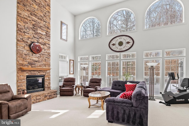 living room featuring a stone fireplace and carpet