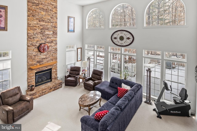 living room with a fireplace, carpet, and a high ceiling