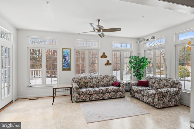 sunroom / solarium with ceiling fan and french doors