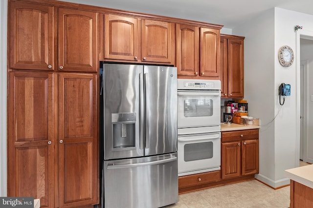 kitchen featuring stainless steel fridge and white double oven