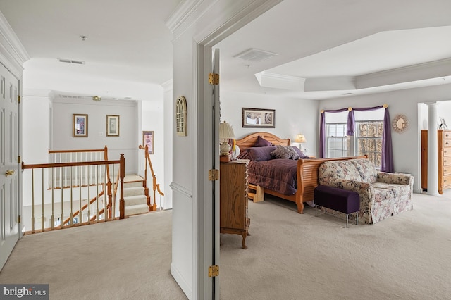 bedroom featuring crown molding, a tray ceiling, and light carpet