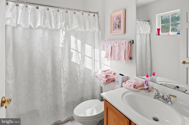 bathroom with vanity, curtained shower, and toilet