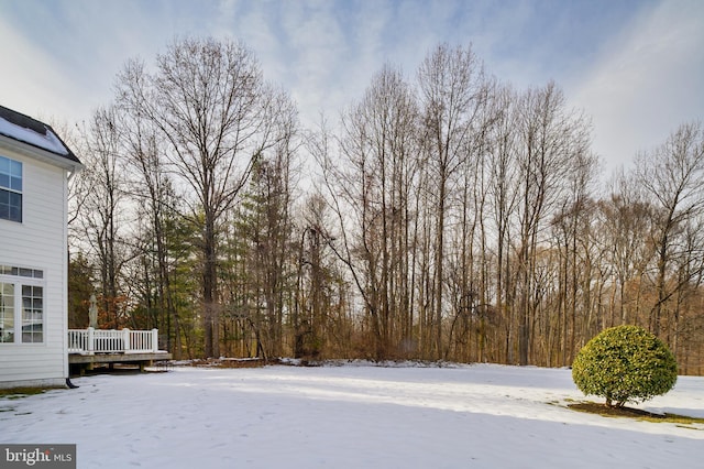 yard layered in snow featuring a deck