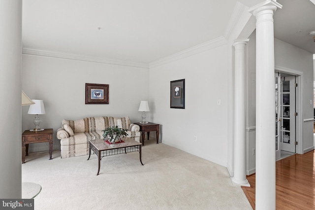 carpeted living room with decorative columns and crown molding