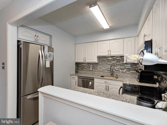 kitchen featuring white cabinetry, sink, backsplash, kitchen peninsula, and stainless steel appliances